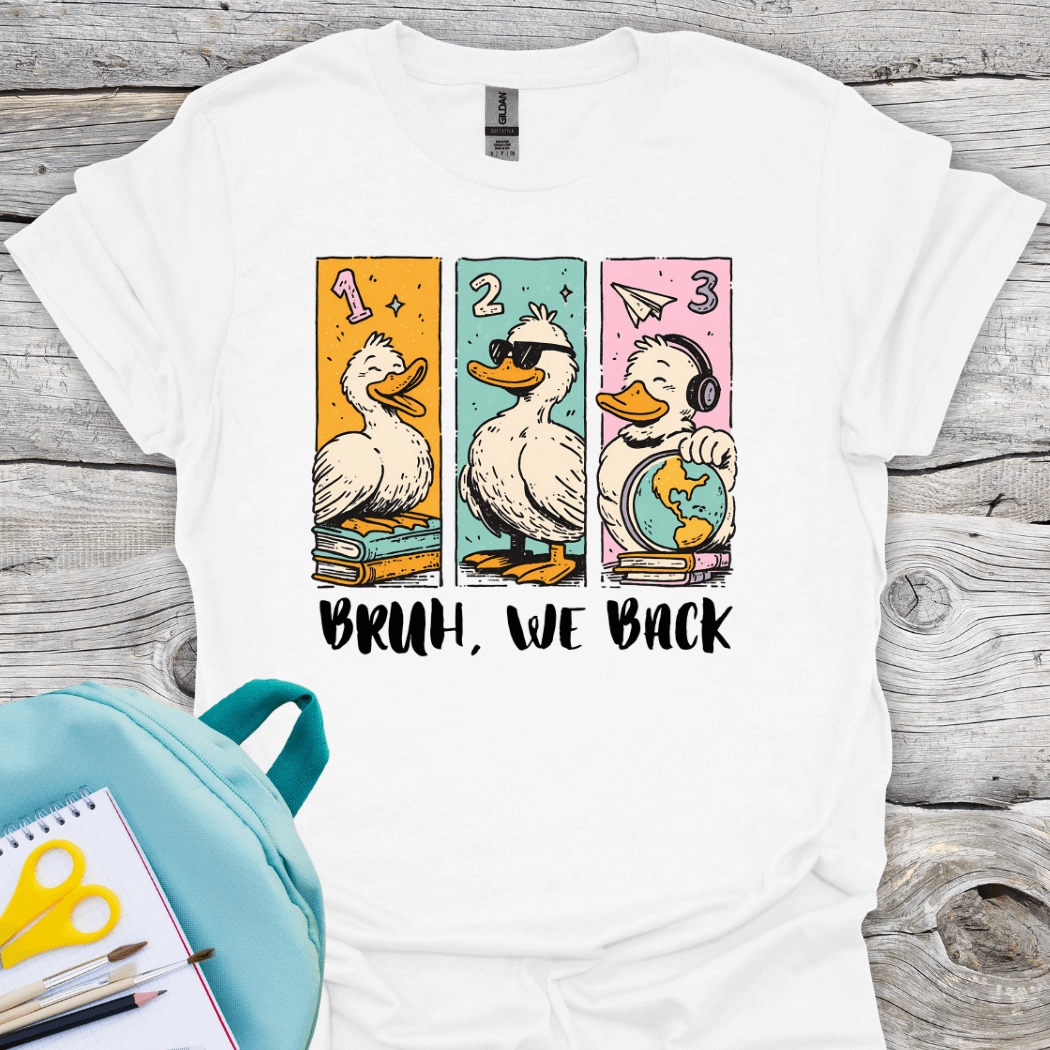 White t-shirt with cartoon ducks and text on a wooden surface with Bruh, we back back to school text