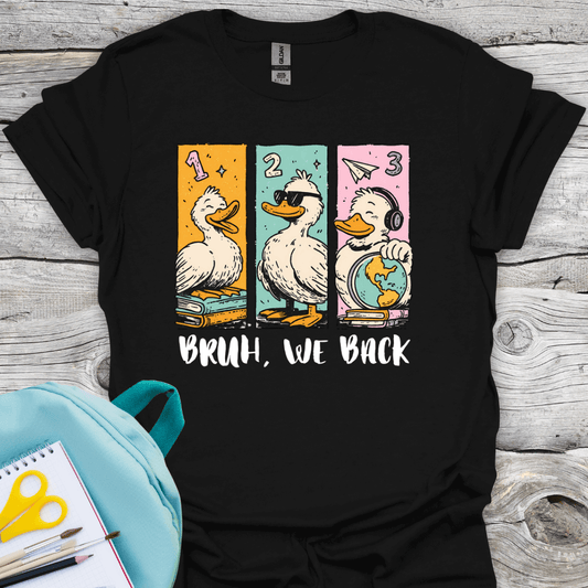 Black t-shirt with graphic design of three ducks and text 'BRUH, WE BACK' on a wooden surface.